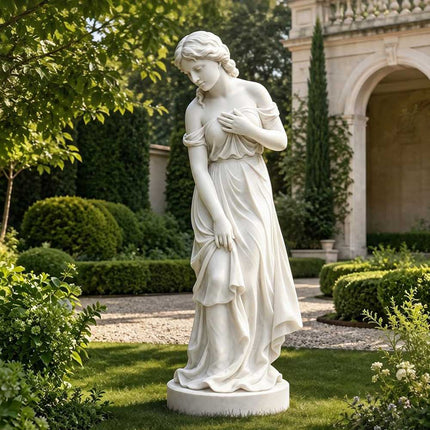 Marble female statue displayed on a lawn in a landscaped residential garden