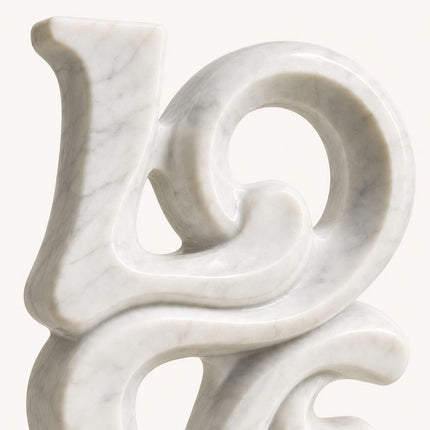 Marble sculpture detail showing rounded curves, open space, and natural stone veining