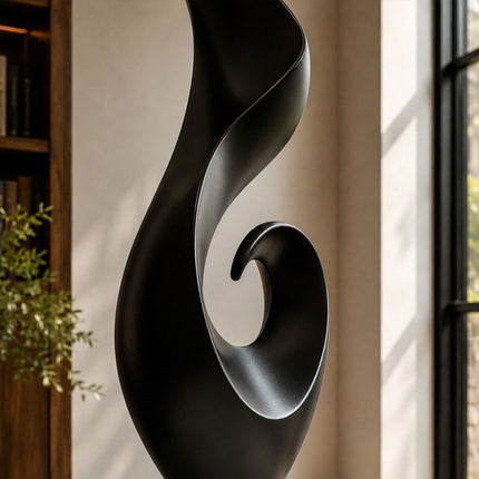 Close detail of matte black stainless steel surface and sculptural curved form