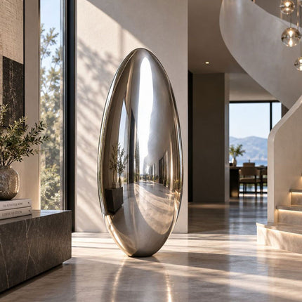 Minimalist stainless steel sculpture with an elongated oval form in a contemporary interior