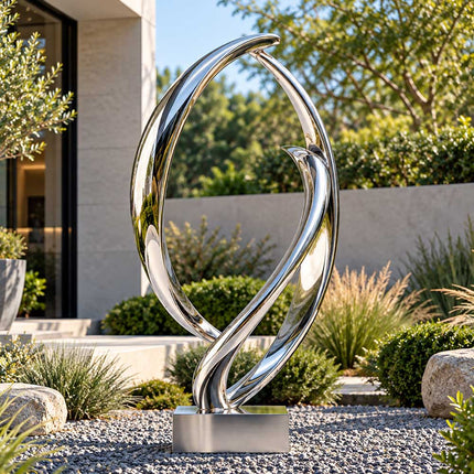 Mirror polished stainless steel loop sculpture displayed in a landscaped private garden with gravel and modern residential architecture