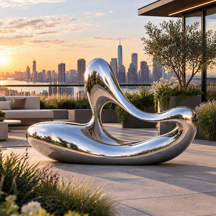 Flowing stainless steel sculpture with a reflective organic form displayed on a contemporary private terrace overlooking the city.