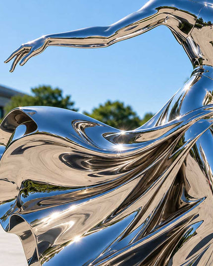 Close-up detail of reflective stainless steel surface on a contemporary figurative sculpture
