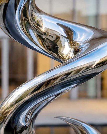 Close-up detail of mirror polished stainless steel surface and curved spiral form