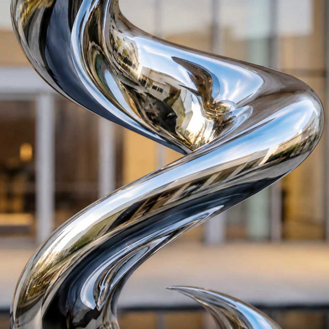 Close-up detail of mirror polished stainless steel surface and curved spiral form