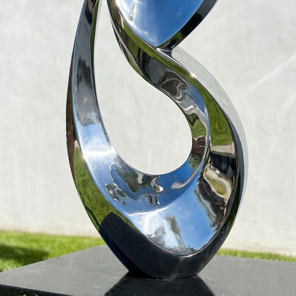 Close detail of mirror polished stainless steel curves on abstract sculpture