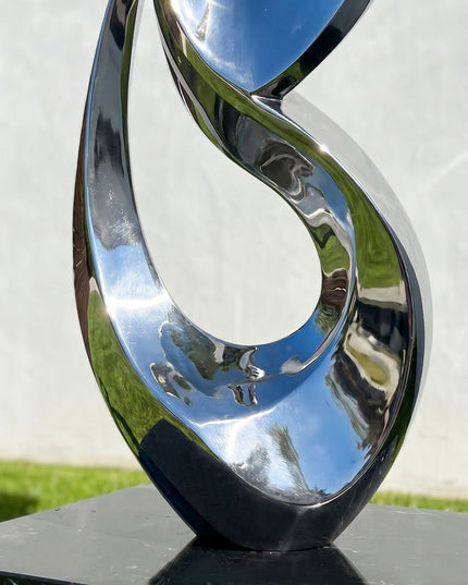 Close detail of mirror polished stainless steel curves on abstract sculpture