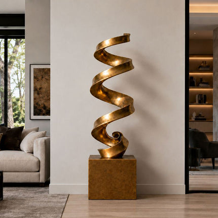 Modern abstract bronze sculpture with spiraling ribbon form in a contemporary interior