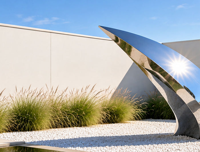 Modern stainless steel sculpture in a contemporary architectural landscape