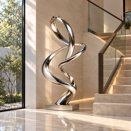 Modern stainless steel sculpture displayed beside a staircase in a contemporary residential interior