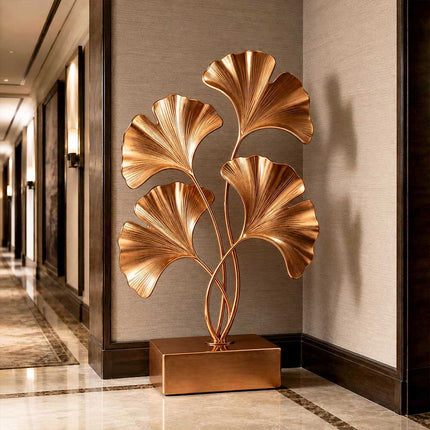 Gold stainless steel ginkgo sculpture displayed in a luxury architectural interior