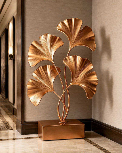 Gold stainless steel ginkgo sculpture displayed in a luxury architectural interior