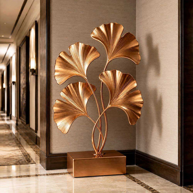 Gold stainless steel ginkgo sculpture displayed in a luxury architectural interior