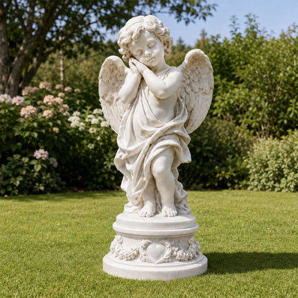 Marble angel statue displayed in a landscaped outdoor garden
