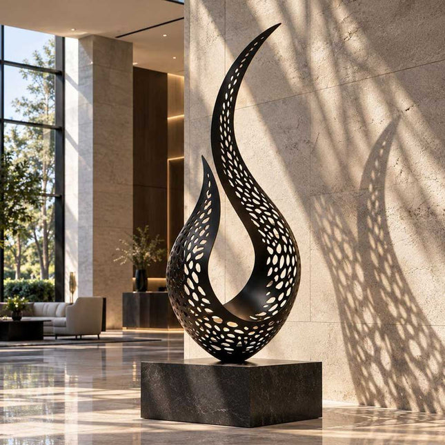 Black perforated abstract stainless steel sculpture casting patterned shadows in a modern interior