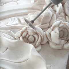 Polishing a white marble sculpture to achieve a smooth, refined surface before the final finish.
