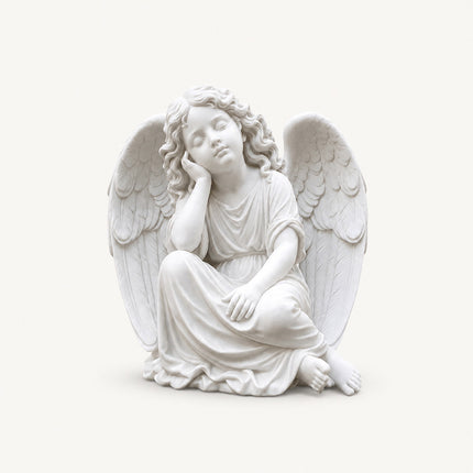 Resting angel statue carved in natural marble with classical religious sculpture details