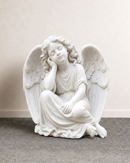 Resting angel statue carved in natural marble with classical religious sculpture details