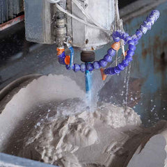 Diamond saw cutting a white marble block during the rough shaping stage of marble sculpture production.
