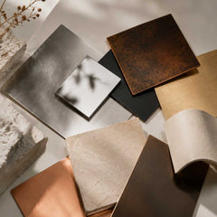 Selection of sculpture materials including stone, bronze, and stainless steel samples showing different textures and surface qualities