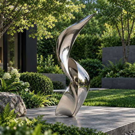 Modern stainless steel sculpture with reflective flowing forms in a landscaped garden