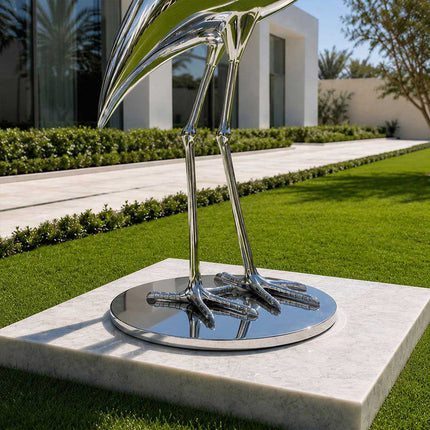 Detailed view of stainless steel heron sculpture legs and integrated round base