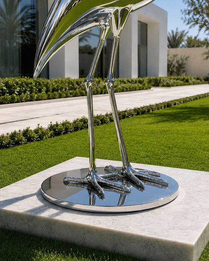 Detailed view of stainless steel heron sculpture legs and integrated round base
