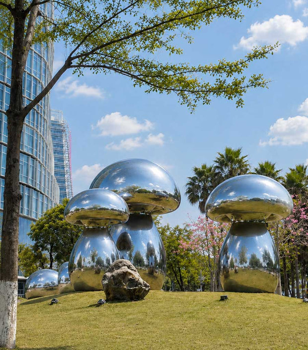 Mirror polished stainless steel mushroom sculptures in a landscaped public park