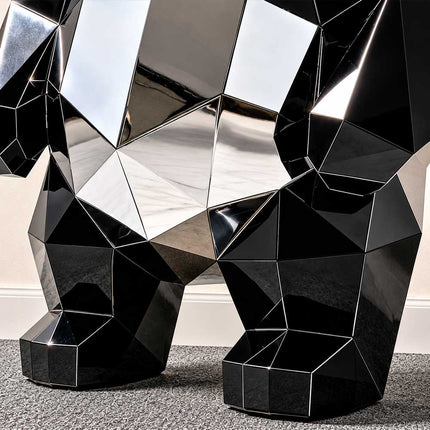 Close-up of the angular stainless steel facets and black polished surfaces on a panda sculpture