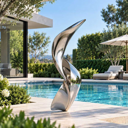 Abstract stainless steel sculpture with flowing organic forms beside a modern pool