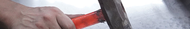 Artisan forging stainless steel sculpture into organic artistic form