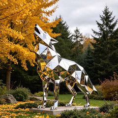 Stainless steel sculpture in modern architectural landscape reflecting sky and surrounding environment.