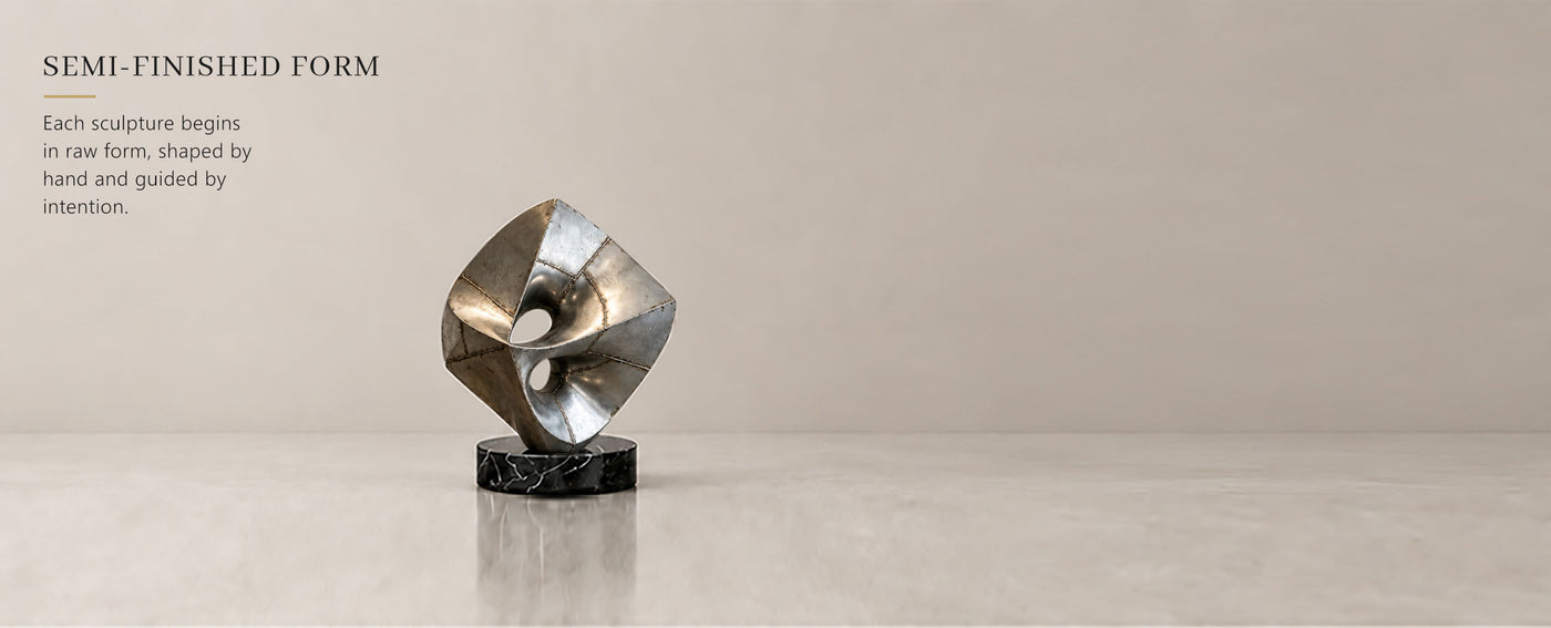Semi-finished stainless steel sculpture before polishing, showing welded panels and handcrafted metal fabrication.
