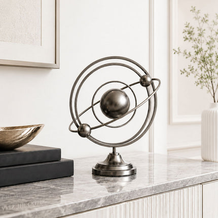 Stainless steel tabletop sculpture displayed on a modern console table interior