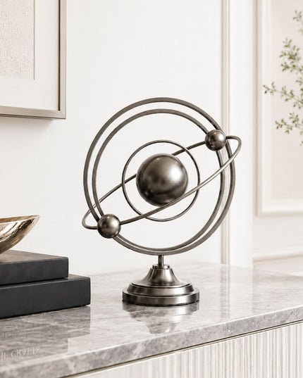 Stainless steel tabletop sculpture displayed on a modern console table interior