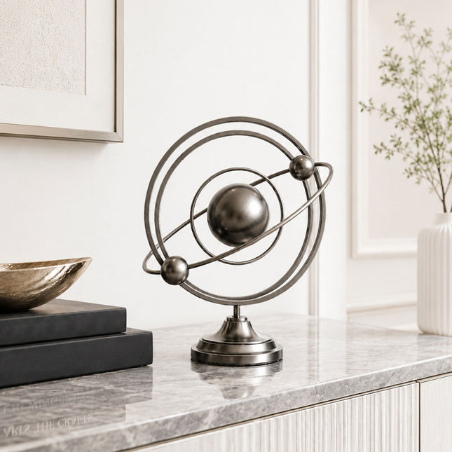 Stainless steel tabletop sculpture displayed on a modern console table interior