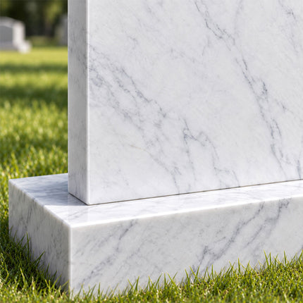 Close-up of the gray veining in a white marble headstone and its matching rectangular stone base