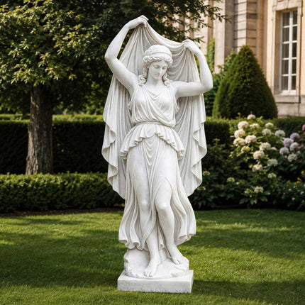 White marble woman statue standing on a lawn in a landscaped residential garden